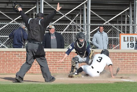 The umpire emphatically signals Lees safe on a close play at the plate.