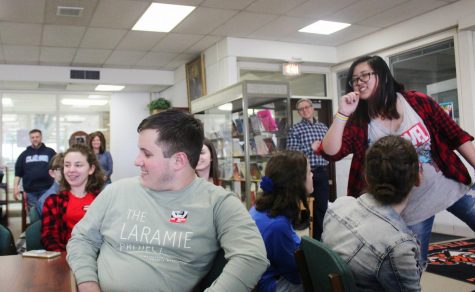 Presenting with fellow members of Erika’s Lighthouse, senior Christina Hu (far right) threw wristbands with messages promoting the organization’s goal of increasing awareness of adolescent depression to audience members who answered questions during the gathering.