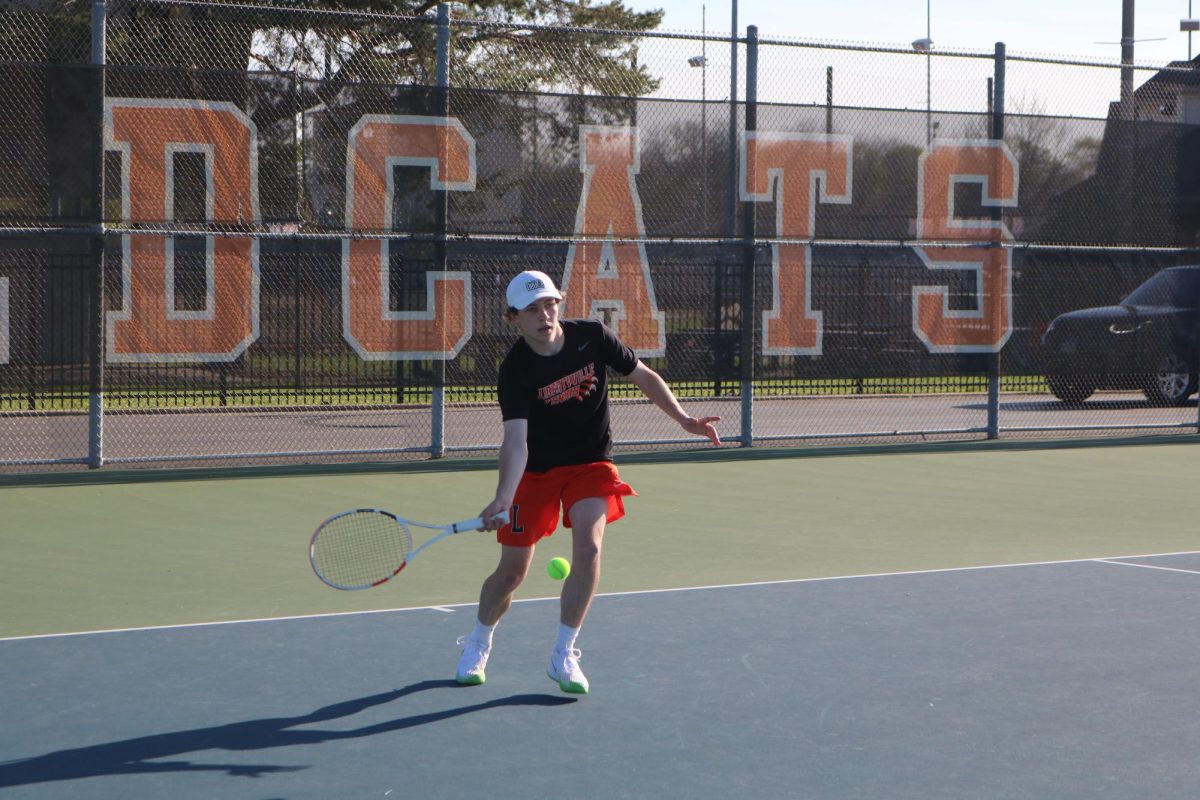 Senior varsity member Grant Angelbeck serves an overhead smash during the first set of his singles game. Grant is the co-captain of the team alongside Jack Gerber.