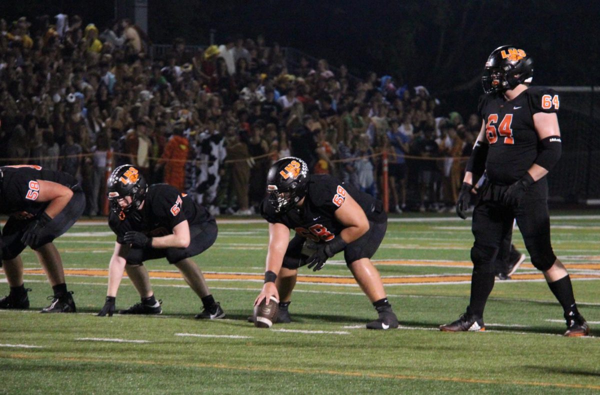 Senior linebacker Max Frazin (68) is in position to hike the ball in the second quarter of the game. The Cats were up 13 points before halftime started.