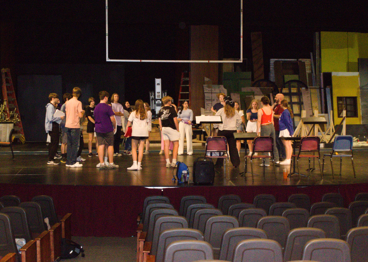 In this photo, you can see members of the theater club grouping together and getting ready for rehearsal in the auditorium.