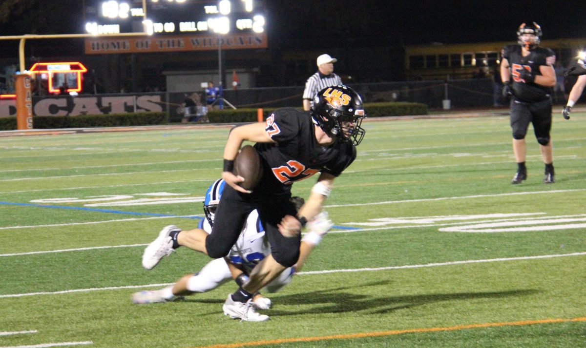 Senior Steven Strelow (27) dodges a tackle attempt from Lake Zurich and preserves down the field.