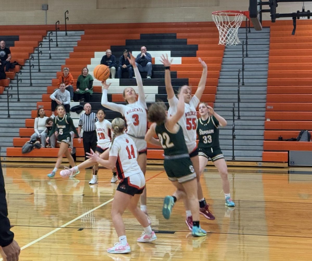 Sophomore Lily Fisher (3) leaps to prevent the ball from falling into the opposing team’s  basket. She turned the ball away when she lept.
