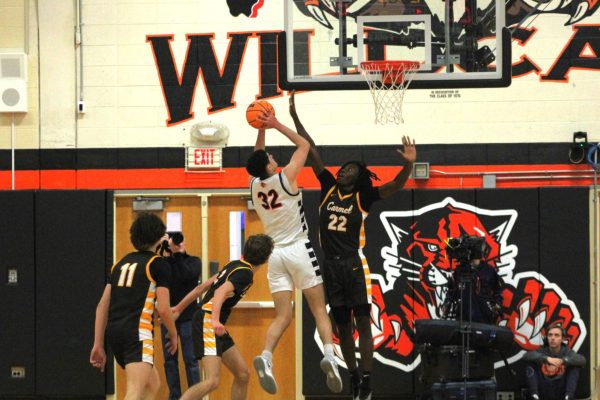 Junior Bryce Wegrzyn (32), rises above a cluster of Carmel Catholic defenders, attempting to shoot a basket.