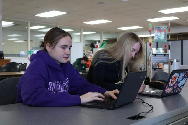 Juniors Mary Minogue (left) and Leah Simpson (right) write their essays together in the library. Creating an environment you feel comfortable and focused on writing can help minimize writer's block.